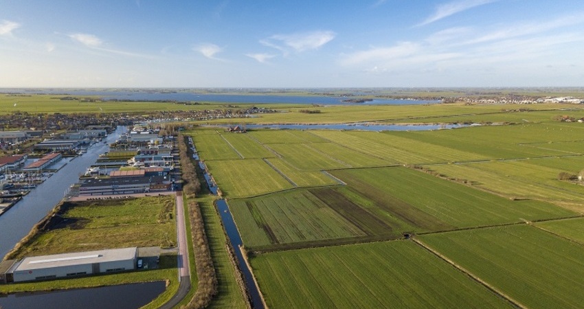 Luchtfoto van een landschap met weilanden en water